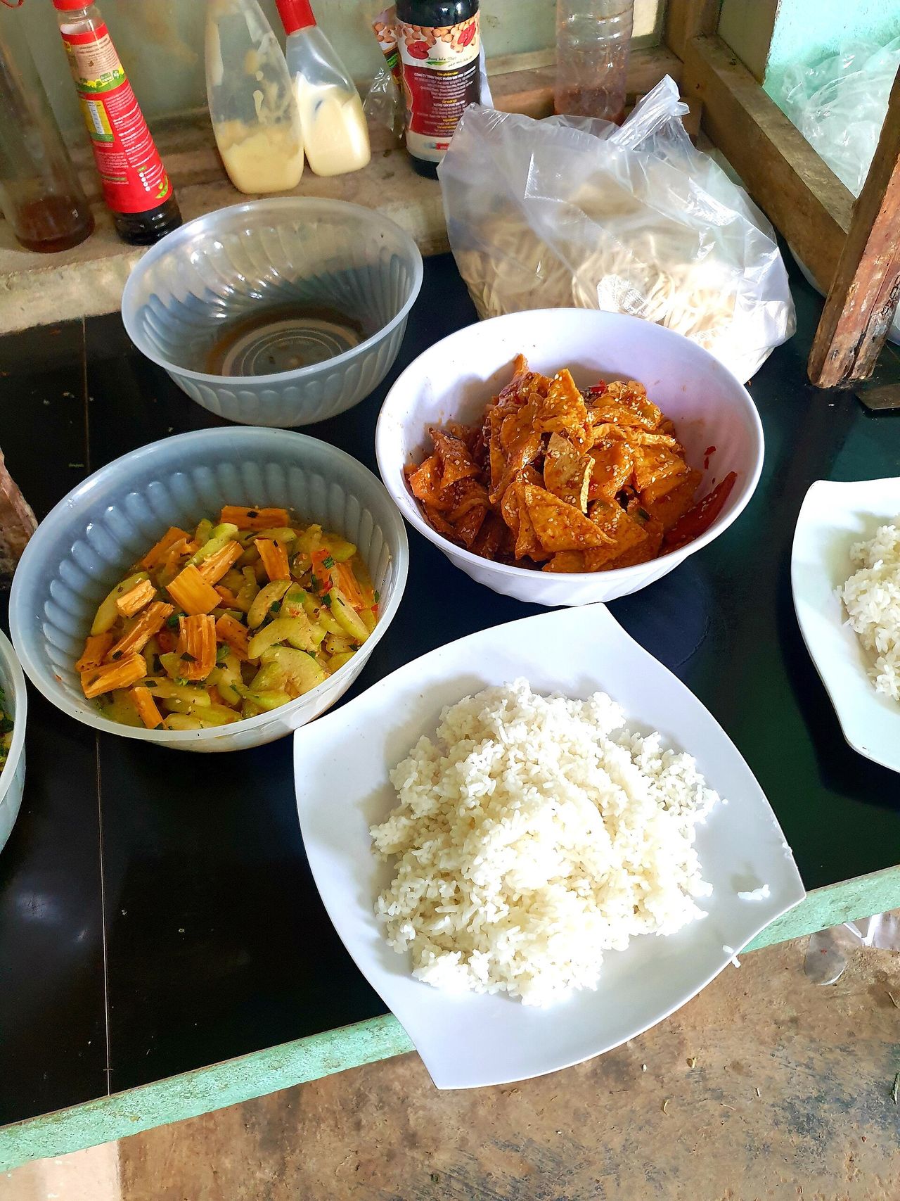 ご飯と豆腐・湯葉・野菜のおかずが並ぶ、ベトナムの菜食食堂のカウンター
