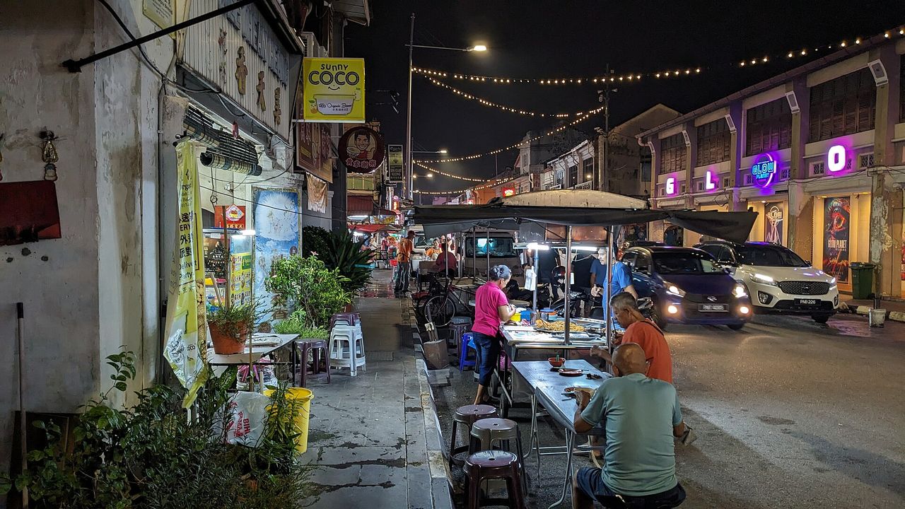 夜のジョージタウン、キンバリー通りに並ぶ屋台と、屋外の席で食事をする人々
