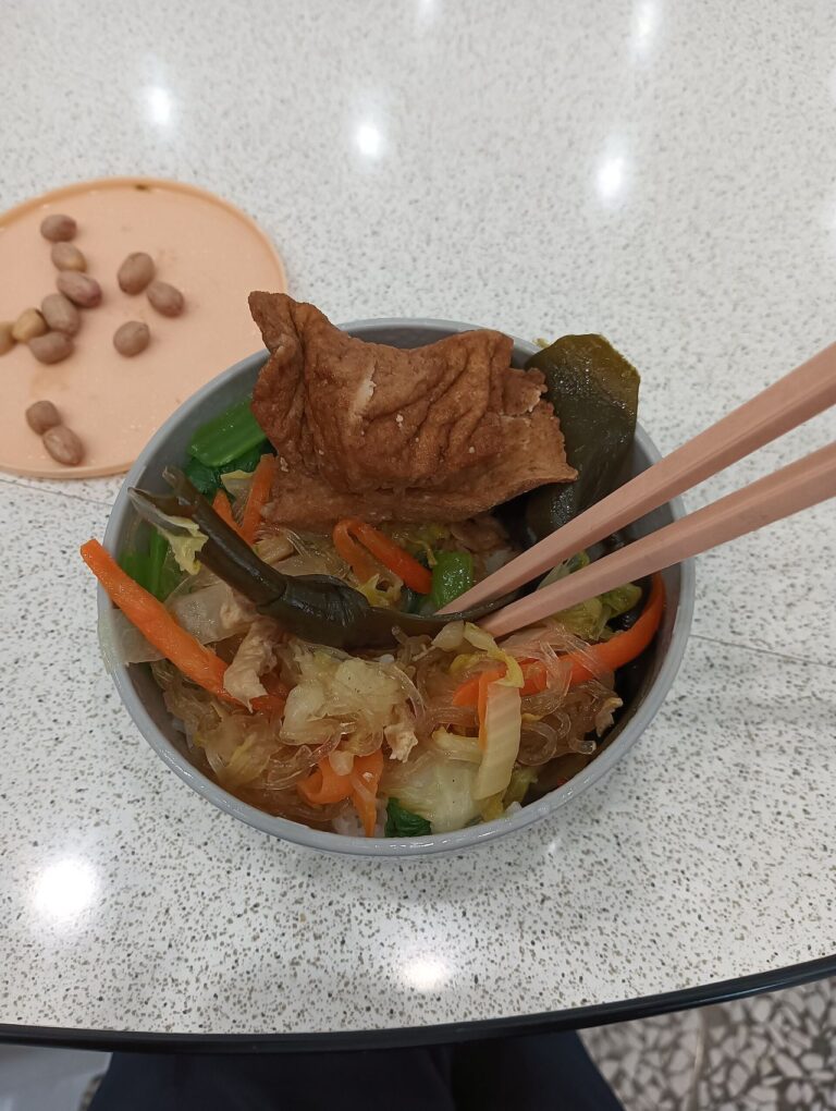 A Taiwanese vegetarian rice bowl topped with vegetables, kelp, glass noodles and fried bean curd